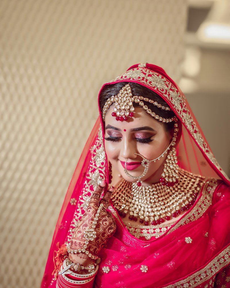 Bridal model in a red lehenga with kundan jewellery and dupatta