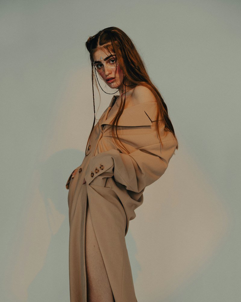 Fashion model in an oversized beige suit on a grey studio backdrop