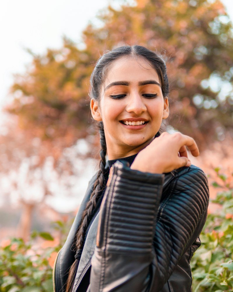 Influencer model in a leather jacket smiling outdoors